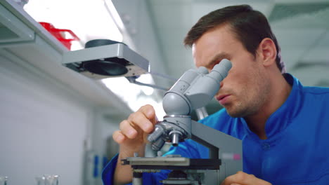 Scientist-student-working-with-microscope.-Male-scientist-looking-microscope